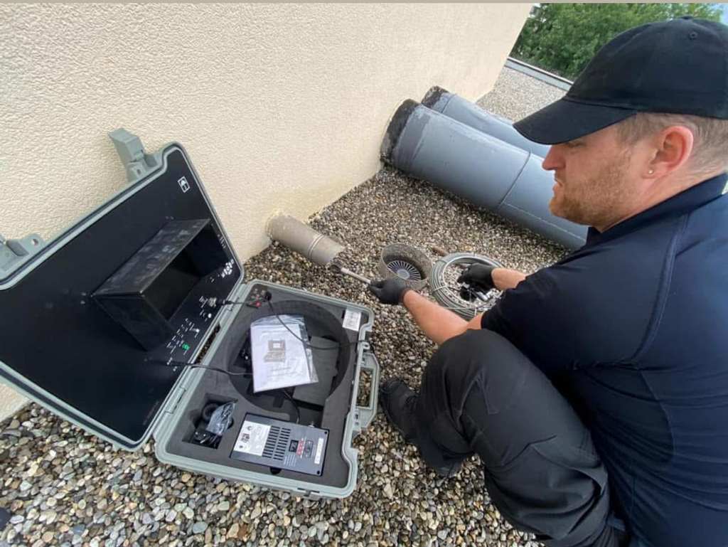 Technicien AZ Sanitaire avec un écran d'inspection caméra de canalisation à Genève